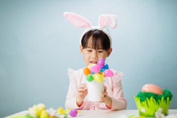 young girl making easter craft against plain background