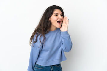 Teenager Russian girl isolated on white background shouting with mouth wide open to the side