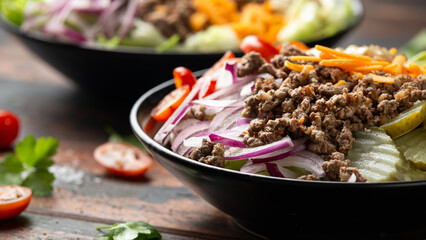 Cheeseburger, hamburger or burger keto salad with beef, fresh tomatoes, red onion, pickled gherkins, lettuce and home made sauce dressing