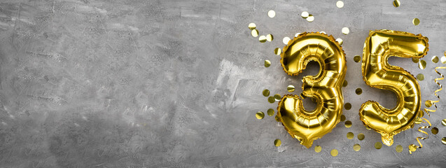 Yellow foil balloon number, number thirty-five on a concrete background. 35th birthday card....