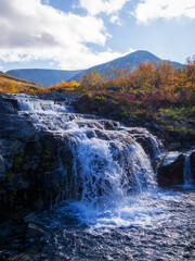 Beautiful mountain waterfall among rocks in polar summer in Khibiny Mountains. Kola Peninsula, Arctic, polar summer