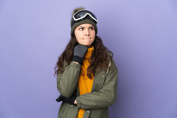 Teenager Russian girl with snowboarding glasses isolated on purple background having doubts and thinking