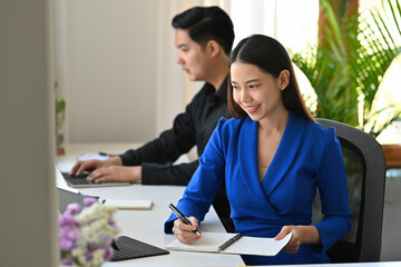 A portrait of a businessman and .a businesswoman sitting in the office working on a data, documents and a laptop on the table with colleague, for business, finance and technology concept.