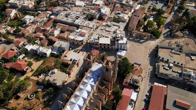 Aerial 4k Lala Mustafa Pasha Camii Mosque or Old Cathedral of Saint Nicholas medieval building with minaret in Famagusta, North Cyprus historical city centre, clear blue sky in sunny day, Cyprus