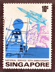Cancelled postage stamp printed by Singapore, that shows Military forces, National Service 10th Anniversary, circa 1977.