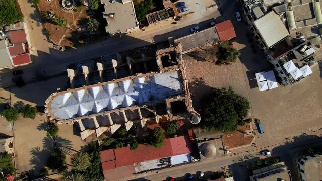 Aerial 4k Lala Mustafa Pasha Camii Mosque or Old Cathedral of Saint Nicholas medieval building with minaret in Famagusta, North Cyprus historical city centre, clear blue sky in sunny day, Cyprus