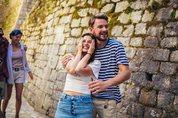 Young millennials friends walking in city old town center on summer vacation
