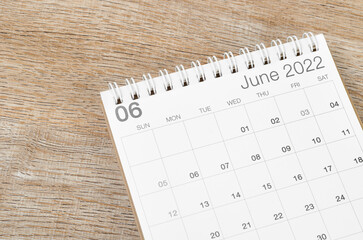 June 2022 desk calendar on wooden background.