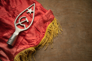 Hammer and sickle on the flagpole.Red flag with yellow tassels from the Soviet Union.Symbols of communism in Russia. A red flag on the table.