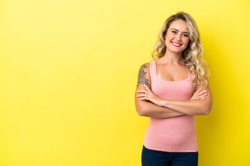 Young Brazilian woman isolated on yellow background keeping the arms crossed in frontal position