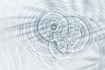 Shadow of palm leaf on transparent water and drops of water falling. Top view, flat lay