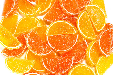 Tasty orange gummy marmalade fruit jelly, sprinkled with sugar candies. Candy and sweet dessert. Top view.