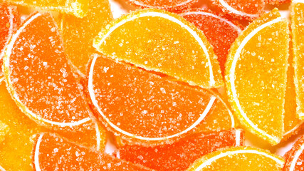 Tasty orange gummy marmalade fruit jelly, sprinkled with sugar candies. Candy and sweet dessert. Selective focus. Top view. - 493775386