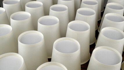 Row of white disposable eco friendly paper cup for coffee or hot beverage on dark backdrop. Selective focus. - 493775398