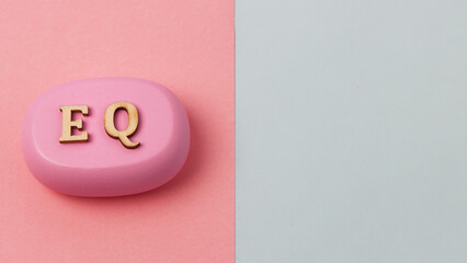 EQ letters symbol on blue and pink background. Wooden signs. Emotional Intelligence concept.