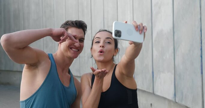 Fit sports couple, young man and woman runners making selfie photos on smartphone after sport fitness training outdoors 
