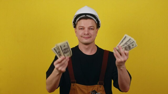 The concept of high construction costs. Rapid outflow of money. Builder in hardhat with money