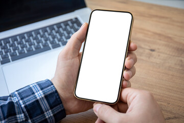male hands holding phone with isolated screen background of laptop