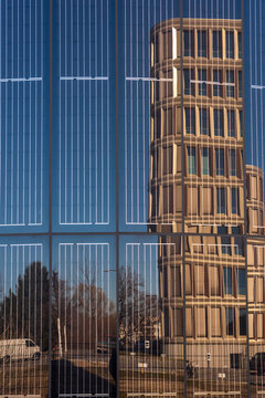 close up of a Facade with integrated solar panels, reflecting a modern office building and blue sky. © Jarama
