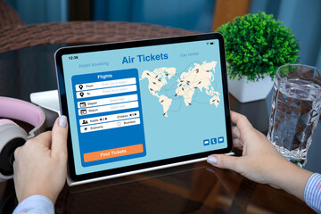 female hands holding computer tablet with application searching air tickets