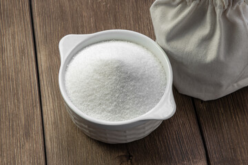 White refined sugar in a bowl and in a bag. The concept of harmful unhealthy food. Glucose and diabetes mellitus. Sugar deficiency