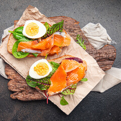 smorrebrod salmon sandwich egg green leaves salad mix, bread toast seafood open sandwich fresh meal food snack on the table copy space food background 