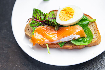 smorrebrod salmon sandwich egg green leaves salad mix, bread toast seafood open sandwich fresh meal food snack on the table copy space food background 