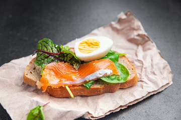 smorrebrod salmon sandwich egg green leaves salad mix, bread toast seafood open sandwich fresh meal food snack on the table copy space food background 