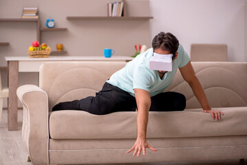 Obraz premium Young man student wearing virtual glasses at home