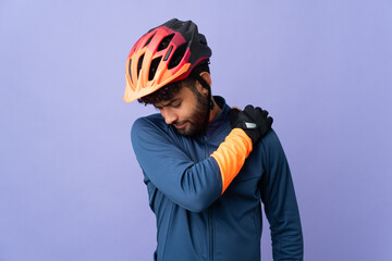 Young Moroccan cyclist man isolated on purple background suffering from pain in shoulder for having made an effort - obrazy, fototapety, plakaty