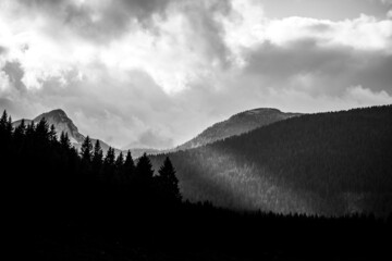 black and white landscape of Slovene mountains with light ray shining