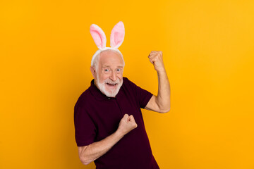Photo of senior man rejoice victory fists hands triumph luck hooray isolated over yellow color background