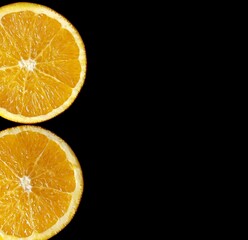 orange slices on the black background with copy space. 