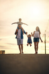Fototapeta premium We love bonding over long walks. Shot of a young family taking a walk down the road outside.