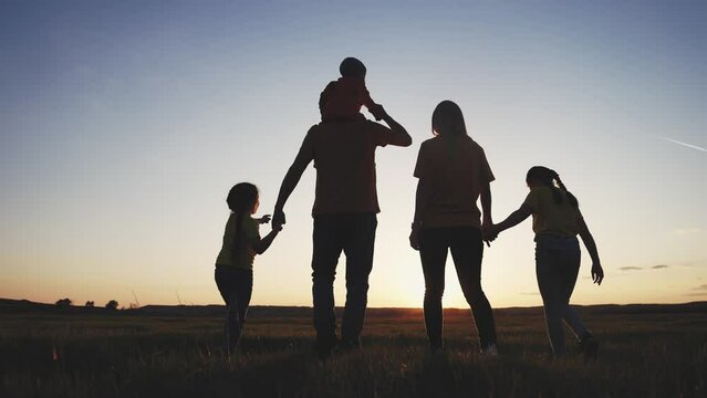 people in the park. happy family walking together in the park silhouette. friendly family kid freedom concept. sunset happy family walking holding hands in the park on the grass. friendly family