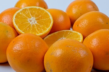 Close up of orange halves with uncut oranges