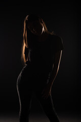 Fototapeta na wymiar Silhouette of girl posing in studio