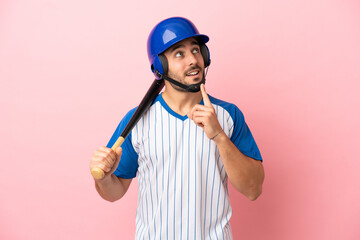Baseball player with helmet and bat isolated on pink background thinking an idea while looking up