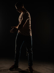 Fototapeta na wymiar Silhouette of a guy posing in studio while standing and enjoying