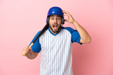 Baseball player with helmet and bat isolated on pink background with surprise expression