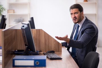 Young male employee in industrial espionage concept