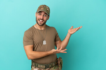 Military with dog tag over isolated on blue background extending hands to the side for inviting to...