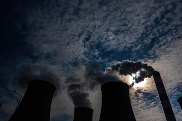 A close-up of the smoke and steam coming out of the chimneys of a coal-fired power plant. The photo...