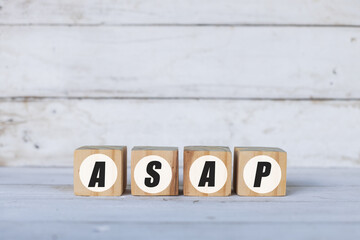 asap concept written on wooden cubes or blocks, on white wooden background.