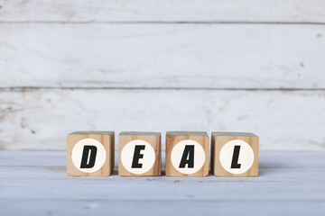 deal concept written on wooden cubes or blocks, on white wooden background.