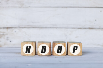 HDHP concept written on wooden cubes or blocks, on white wooden background.