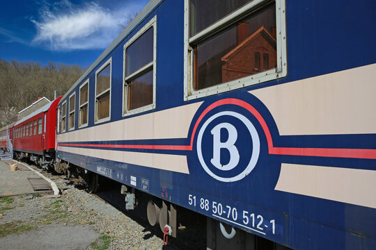 Spontin, Belgium - March 9. 2022: View on ancient historical train wagon on sidetrack with logo lettering of belgian national railway company