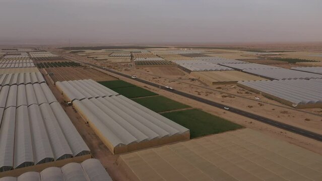 Flying backwards over greenhouses and rural fields in large scale farming community in the Negev desert, Israel
