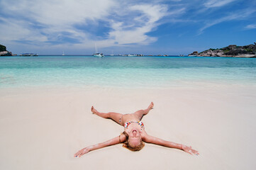 Fototapeta na wymiar Vacation on the seashore. Young woman relaxing on the beautiful tropical white sand beach.