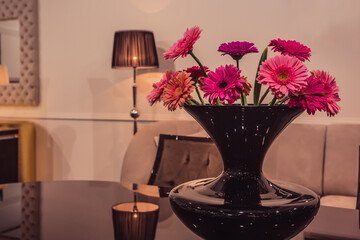 Elegant bouquet of purple gerbera in the glass table in luxury interior